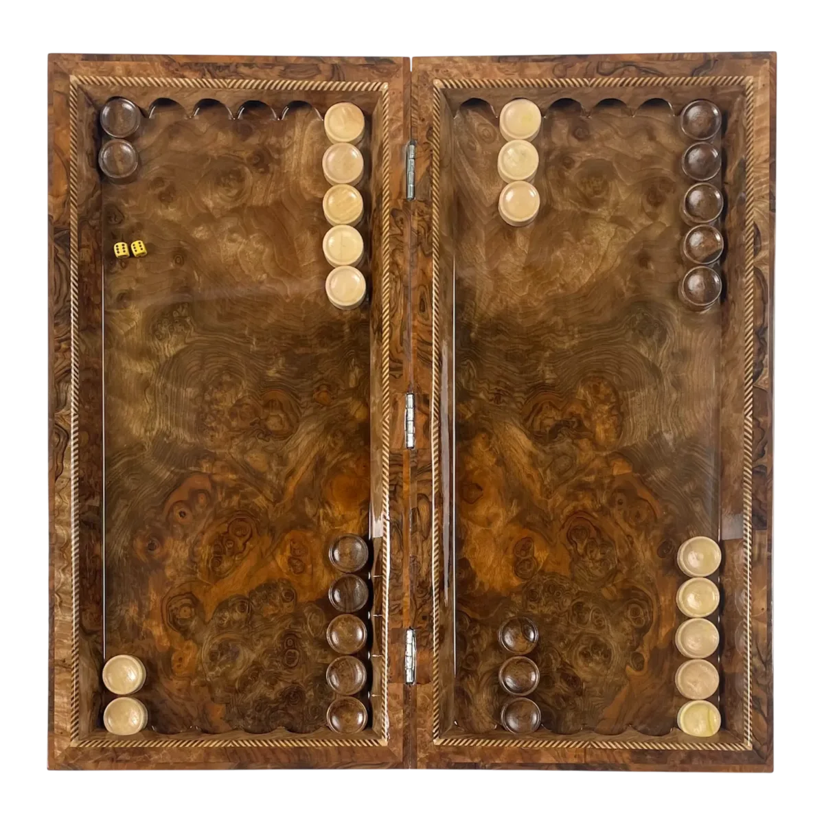 Open backgammon board with light and dark checkers and a pair of dice on the brown patterned playing surface