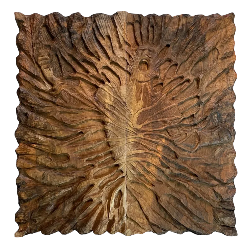 Deep carving on the exterior of a closed backgammon board depicting an open-mouthed human figure amid flames