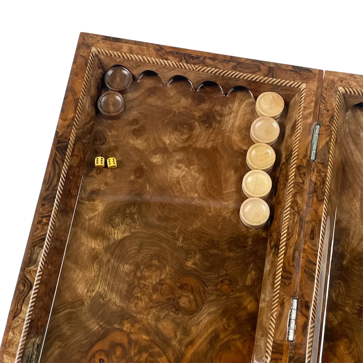 Checkers lined up in the corner of the open backgammon board, two yellow dice and a striped edge band